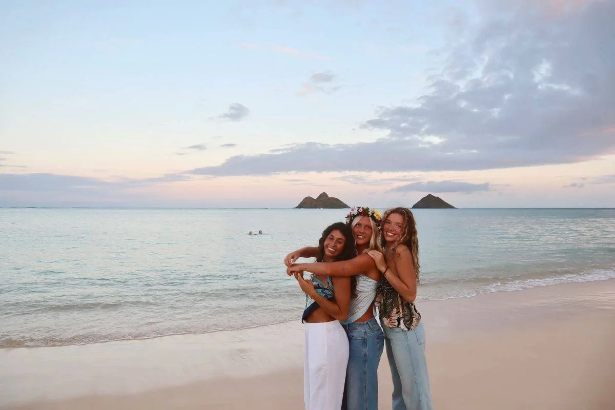 Three women on the beach at sunset